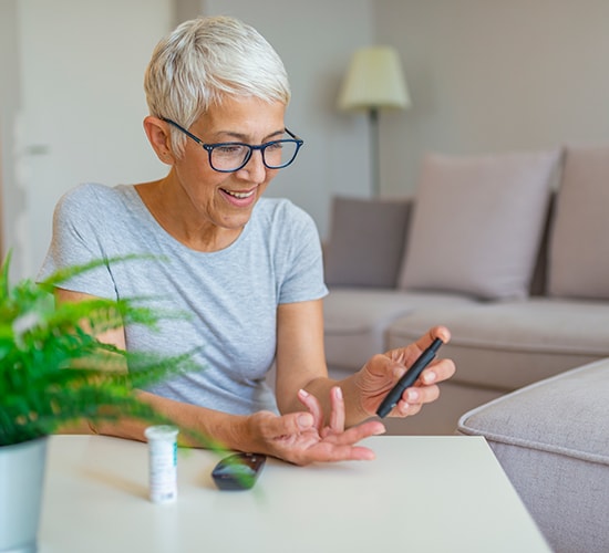 female testing blood sugar at home