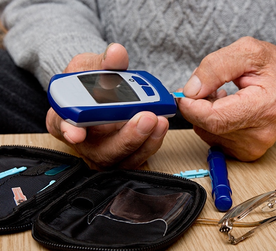 senior conducting home blood glucose test