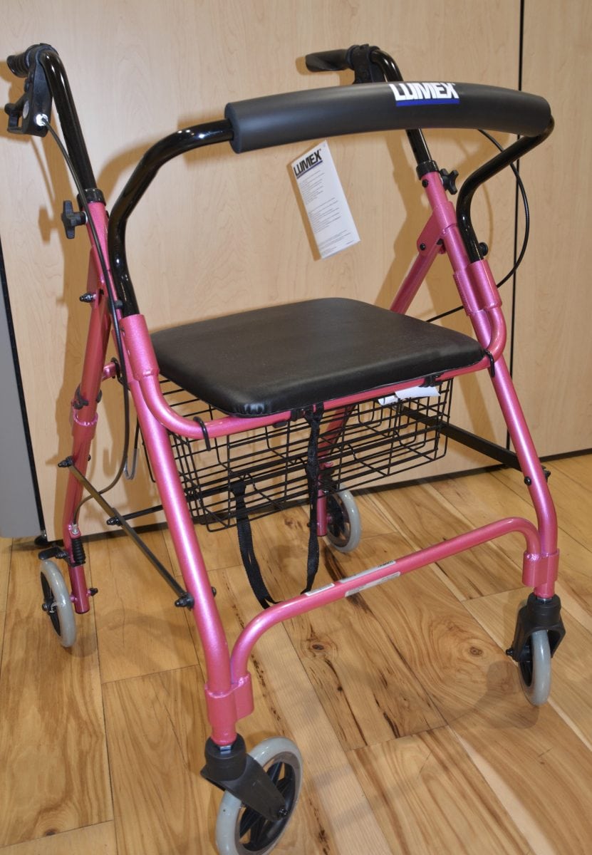 pink colored walker with black seat and handle