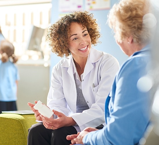 Two women discussing prescription at a pharmacy