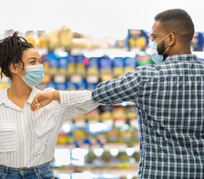 how to prevent the flu_man and woman elbow bumping wearing masks